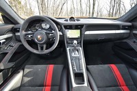 スイッチ類の備わらないステアリングホイールなど、シンプルを旨としたインテリア。グローブボックスの上にはカップホルダーが格納されている。