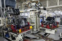 車体へと組み付けられるフロントセクション。アメリカからはるばるやってきたエンジンと、鈴鹿製の6段MT、そして寄居工場内で組み立てられたフロントサスペンションを、サブフレームにセットしたものだ。