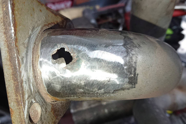 穴の開いたヘダーを修理。まずは腐食部分を削り落として……。それにしても、ご立派な穴である。ここからウン百度もの排気が漏れていたかと思うと、ちょっと怖いんですけど。（写真＝コレクションズ）