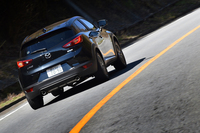 ワインディングロードを駆け上がる「CX-3」。マフラーエンドは全車、左右振り分けの2本出しで、スポーティーなイメージが演出される。
    