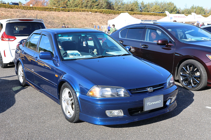 オーナーズミーティングエリアで発見した、今では激レアの「ホンダ・トルネオSiR-T」。6代目「アコード」の姉妹車として登場するも、たった一世代で消滅。「ユーロR」が登場するまでは、最も高性能なMT専用モデルであった。もうひとつの激レアポイントは、モデューロブランドの原点であるアルミホイールを装着しているところだ。