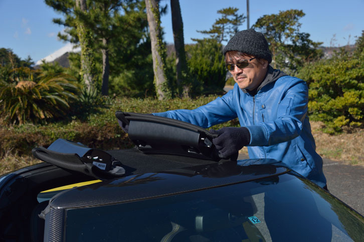 ソフトトップは、左右および前方のロックを解除してから巻き取って外すタイプ。車体後方のラゲッジスペースに収納できる。