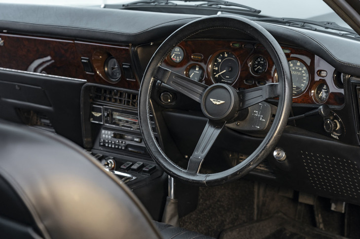 ダッシュボードやトリムにウッドパネルが使われるようになったのが「V8シリーズ4」の特徴。ステアリング位置が不自然に高いドライビングポジションには慣れが必要だが、ハンドリング自体は素直で素晴らしい。ZF製の5段ギアボックスは、左手前が1速のドッグレッグパターン。最新の「ヴァンテージ」に追加された7段MT仕様の元ネタともいえる。