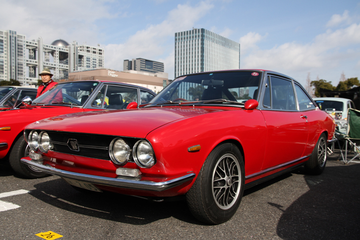 1971年「いすゞ117クーペEC」。ソレックスキャブに替えてボッシュDジェトロニックを備えた、日本初の電子制御インジェクション装着車。ハンドメイド時代の赤いボディーカラーは珍しいが、出荷前にカタログ撮影に使われた個体という。しかもワンオーナー車である。コスミックのアルミホイールとビタローニのセブリングミラーが、モディファイされた時代を物語る。