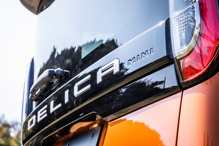 リアハッチガーニッシュに備わる「デリカミニ」のエンブレム。オプションの「アクティブトーンスタイル」では、「DELICA」の文字が大きくホワイトで入り、その横に小さく「MINI」の文字が刻まれる。