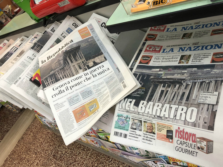 2018年8月15日、イタリアは国民の祝日。販売スタンドに並ぶ新聞は、前日発生した橋崩落事故を一面で伝えた。「戦争の如く」「深淵（しんえん）」といった見出しが並ぶ。