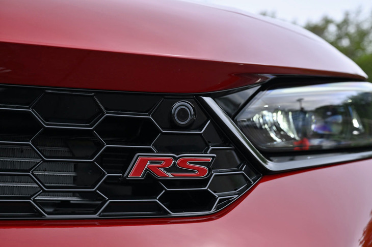 グリルに「RS」のエンブレムが備わる「シビックe：HEV RS」のフロントフェイス。ヘッドランプベゼルやアッパーサイドガーニッシュがブラックでコーディネートされるのも同モデルの特徴だ。外板色は写真の「プレミアムクリスタルレッド・メタリック」を含む、全5種類から選択できる。