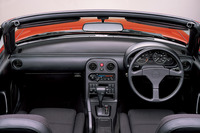 シンプルなT字型のインストゥルメントパネルが採用された「ユーノス・ロードスター」のコックピット。ルーフは手動開閉式のソフトトップで、SMCプラスチック製のデタッチャブルハードトップもオプション設定されていた。