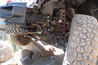 試乗車の足まわり（フロント）をのぞき込む。この「ルビコン」モデルはノーマルと異なり、ボタン操作でサスペンショントラベルを延長できる。