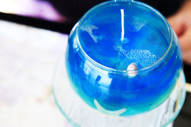 器の中がきれいなロウでいっぱいになりました。後は水面に貝殻を飾り、ラメを振りまいたら完成です！