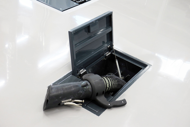 作業スペースの床には、マフラーに装着して用いる排出ガスの排気パイプが埋め込まれている。リフトに上げたクルマの排気を屋外へ排出するための設備だ。