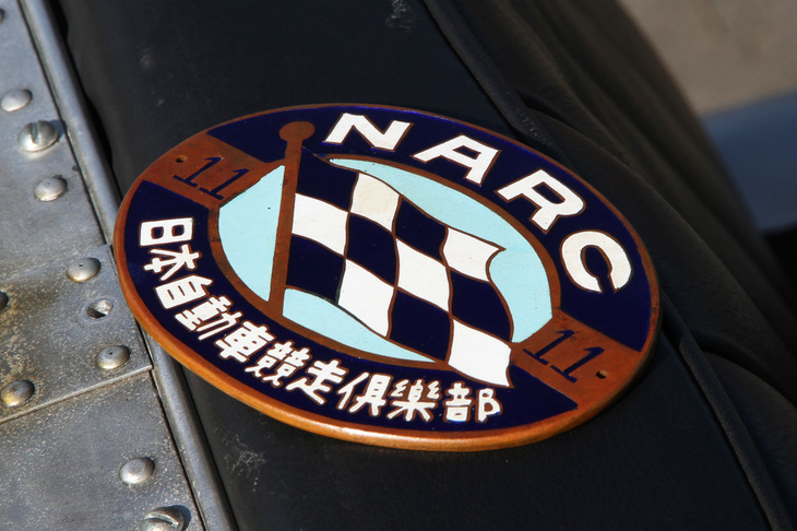 レースの参加者が所属していた「日本自動車競争倶楽部」の会員証を兼ねたエンブレム。11は会員番号にしてカーナンバーである。多くのメンバーが車両に取り付けて出走していたという。