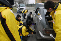 「TE27トレノ」をサービス中の学生たち。彼らがまとっているチームウェアには、きちんとスポンサーロゴが貼られているが、じつは手作り。パソコンで制作したスポンサーロゴを、既成のジャケットに1枚ずつアイロンでプリントしたのだという。（写真＝OYC 吉野裕仁）