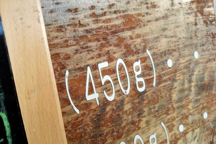 お店の看板に書かれた「450g」の文字。同じワンポンドなのに、沼津では450g、伊東では420gと、30gの差が生じているのはなぜか？　偉い学者先生にぜひ解き明かしてほしい。