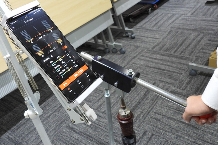 スマートフォンのアプリによる減衰力調整のデモンストレーション。画面をタップして「Comfort」モードを選ぶと、ダンパーを収縮させるレバーがスッと軽くなる。