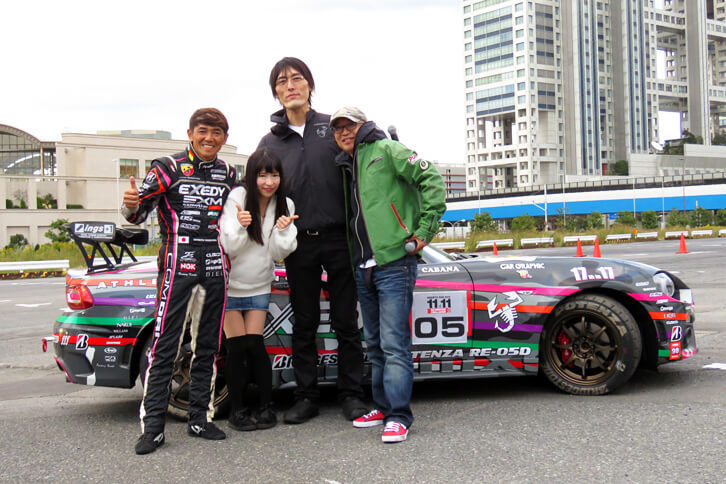 「アバルト124スパイダー」とともに記念撮影に応じる4人。右からピストン西沢氏、ジャイアント白田氏、もえのあずき氏、山野哲也選手。