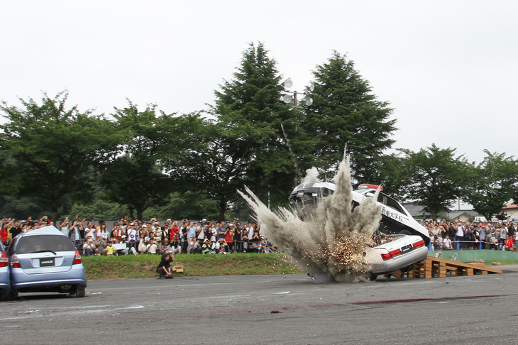 ハイライトは発破（火薬による爆発）を仕込んだTボーンアタック。ジャンプ台を通過した「グロリア」が、11代目「トヨタ・クラウン」を踏み台としてさらに角度をつけ、上空に向かってカタパルトから射出されたように飛び出す。