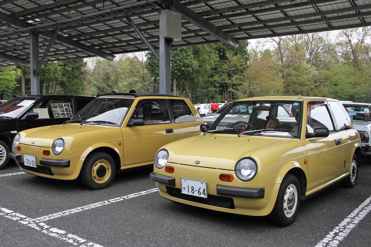 イメージカラーのパンプキンイエローをまとった双子の1988年「日産Be-1」。初代「マーチ」をベースとしたパイクカー第1弾。1985年の東京モーターショーにコンセプトカーとして出展したところ、大好評だったため市販化が決定。1987年1月に1万台限定で発売されると予約が殺到し、急きょ抽選販売となるなど話題には事欠かなかった。
