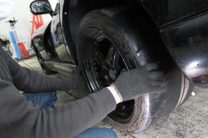 左リアタイヤを揺さぶるメカニック氏。読者諸兄姉におかれては、そんなことよりタイヤからのぞく臓物（ベルト）のほうが気になるかもしれない。