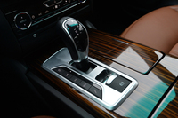 8段ATをつかさどる電子制御式シフトレバー。その左側には、走行モードの選択スイッチがずらりと並ぶ。写真でシフトレバーの右側に見えるのは、電動式パーキングブレーキの操作スイッチ。
    