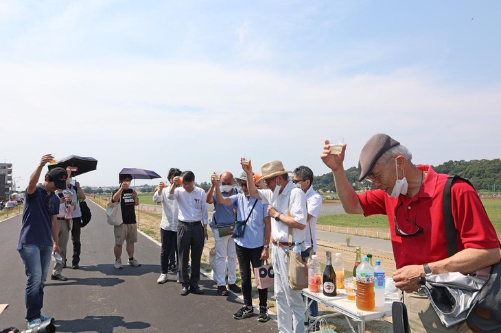 突然の取り壊し通告から1年後の2022年7月2日に実施されたお披露目および報告会で、献杯する多摩川スピードウェイの会のメンバーとゲスト。