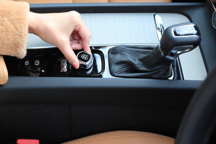 指先でつまんでいるのは、エンジンのスタートスイッチです。最近、エンジンの始動は“押す”タイプが多いと思いますが、あえて“ひねる”という動作にしたのはボルボのこだわりですね。この動き、女性の手を美しく見せてくれます。