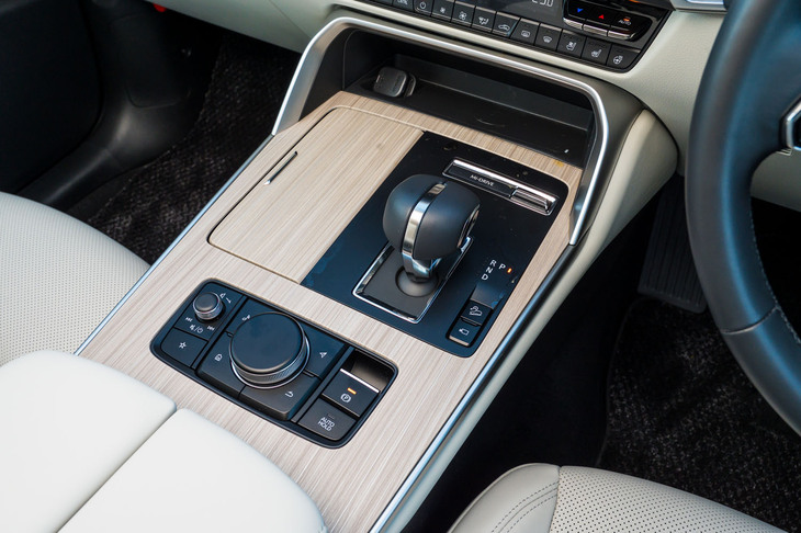 センターコンソールやドアパネルなどには光沢のあるウッド調パネルが貼られる。シフトセレクターまわりの樹脂は国産車だとピアノブラックのケースが多いが、マット調にするのがマツダ流。