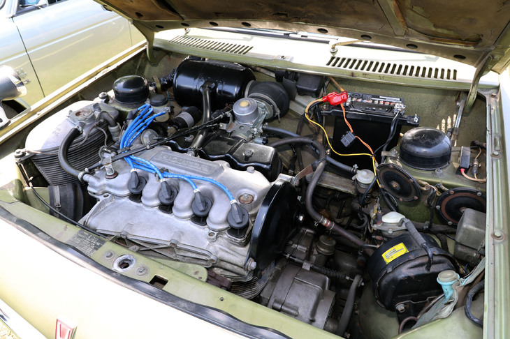 「ホンダ1300 77S」のエンジンルーム。横置きされ前輪を駆動する1.3リッター直4 SOHCユニットは、熱烈な空冷の信奉者だった本田宗一郎肝いりのDDAC（二重空冷）という特異な設計で、空冷ながら静粛性に優れていた反面、凝った構造ゆえ重量は水冷並みかそれ以上だった。しかも実用車でありながら潤滑方式はドライサンプで、左手前にあるフィン付きのアルミの鋳物がオイルタンク。