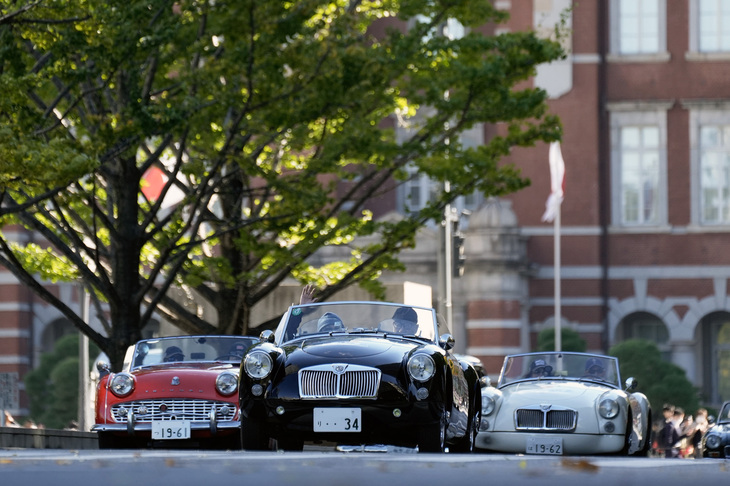 東京駅を背景に行幸通りを行く、1960年前後のイギリス製オープン2座スポーツの代表的なモデルである「MGA」と「トライアンフTR3」。