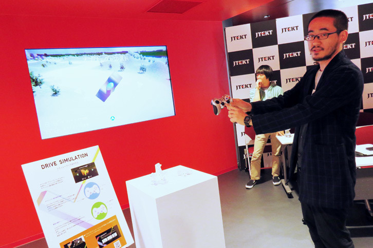 ドライブシミュレーターの説明をする多摩美術大学の谷口暁彦講師。