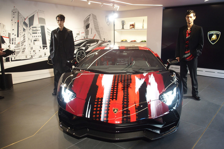 「アヴェンタドールS“dressed”by Yohji Yamamoto」とファッションブランド「Yohji Yamamoto」のコレクションに身を包んだモデル。