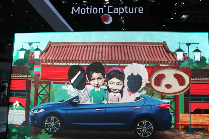 北京現代のブースで。「モーション・キャプチャー」のデモを、コンパニオン（左）と体験する筆者（右）。