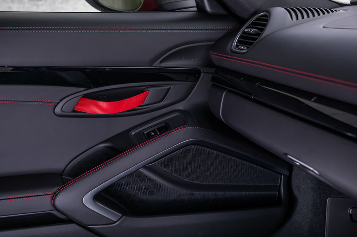 軽量化の一環として採用されるナイロン製のストラップ式ドアオープナー。通常は黒色だが、今回の試乗車はオプションのアクセントカラーによって、ガーズレッド色となっていた。