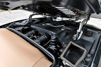 キャビンの後方に収まるV10ユニットは、550ps/8000rpmと55.0kgm/6500rpmを発生。そのエンジンフードは、ルーフの開閉リッドの役目も兼ねる。写真手前に見えるベージュ色のソフトトップは、オプション扱い（18万5220円）である。