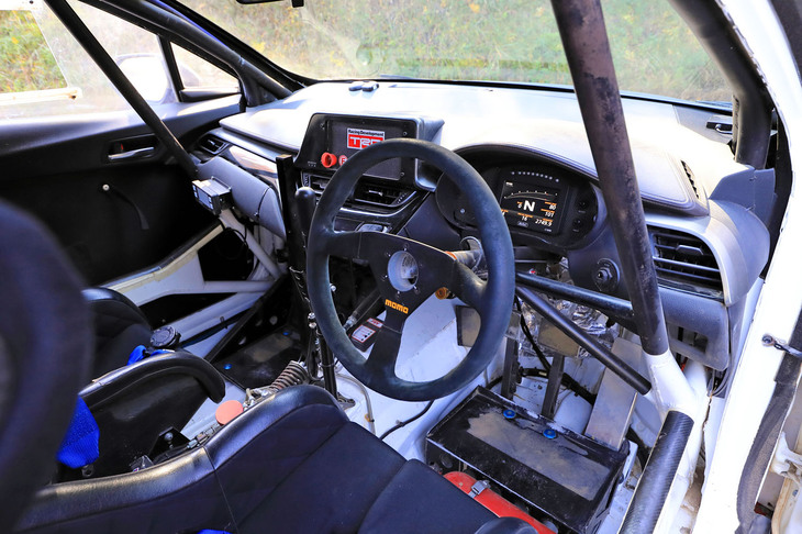 “がらんどう”にロールケージを張り巡らせた車内は、（当然ながら）まさに競技車両といった趣。サイドブレーキと並んで屹立（きつりつ）するシフトレバーからも分かるとおり、5段のトランスミッションはシーケンシャルタイプで、オランダのDrenth（ドレンス）製のユニットが搭載される。