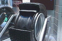 
	トラックやバスのタイヤは大きな重量を支えるため、従来はタイヤを2本一組で装着していた。「GREATEC」は、それを1本でまかなえるように開発された新タイヤ。ただし、1本だとパンクした際に転倒などの危険が伴うため、バースト時に2重構造の内部が膨張して形状を保ち、タイヤがリムから外れたりしないようにする技術が「AIRCEPT」だ。
	 