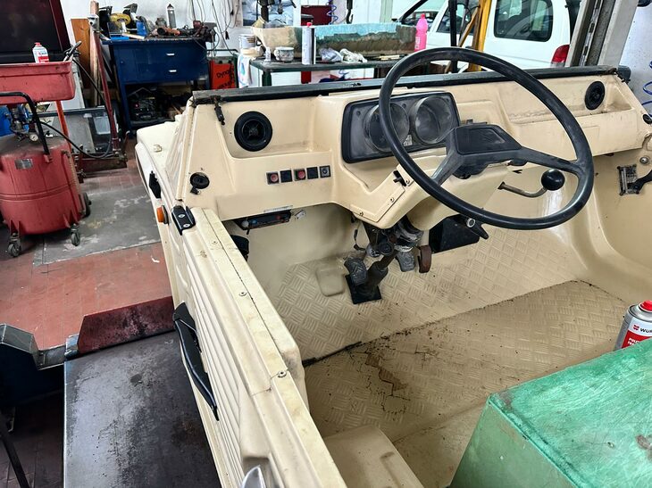 シンプル極まりないダッシュボード。メーターは年式によって異なるが、この個体は左が回転計と警告灯、右が140km/hまで刻まれた速度計である。手前の緑色のものは、作業中のイス代わりに裏返して置いた箱。