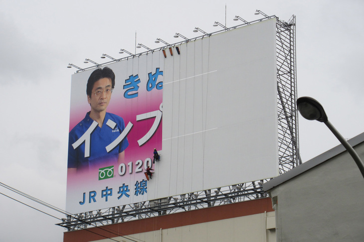 首都高速1号線勝島付近に設置されている「きぬた歯科」の看板。写真は貼り替え前のもの。（写真＝きぬた歯科）