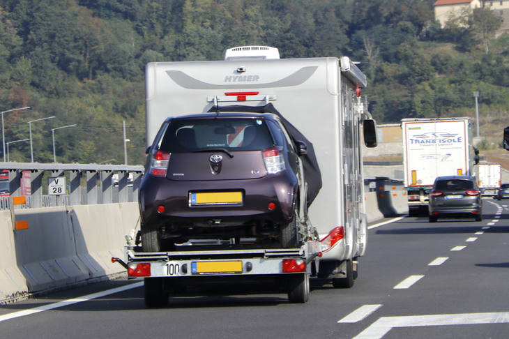 「トヨタiQ」をトレーラーに載せてけん引するキャンピングカー。2020年9月、イタリアで撮影。