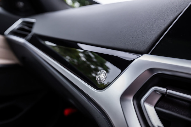 ダッシュボードやセンターコンソール部のパネルは、ピアノブラックの「アルピナインテリアトリム」と呼ばれる専用アイテム。ダッシュボードパネルには、小さなメタルエンブレムも貼られている。