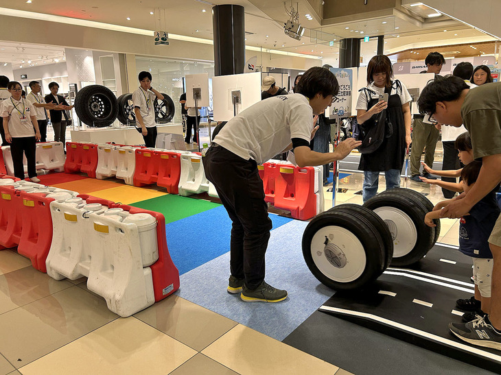 「タイヤゴロゴロ空気圧比較体験コーナー」では、空気が抜けたタイヤと適正な空気圧との“タイヤの転がる距離の違い”を体感。小さな傾斜のあるスタート地点から同時に手を離したそれぞれのタイヤには、どのような差が生じるのだろうか？