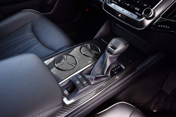 2リッターのガソリンエンジン車には8段ATが、ハイブリッド車には電気式CVTが組み合わされる。写真中央に見える、底面が浮き沈みするカップホルダーは、新型「クラウン」の特徴的な装備のひとつ。