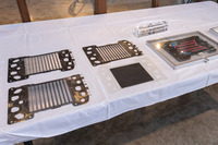 新しいFCセルでは、素材コストの削減や製作工程の効率化も考慮。セパレーターについては、チタン／カーボンのコーティングをプレス成形前に行うことで、連続処理を可能とした。また電極集合体では、成形をエンジニアリングプラスチックの精密射出成形から汎用（はんよう）プラスチックフィルムの打ち抜き成形に変更。電解質膜の製造時に必要だった副資材のベースフィルムを不要とした。