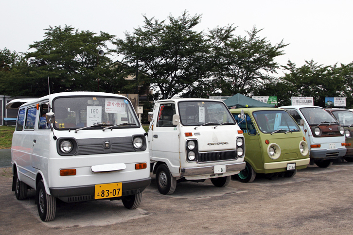 左から1975年「三菱ミニキャブELバン」、74年「ホンダTN-V」、73年「マツダ・ポーターキャブ」、73年「ダイハツ・ハイゼット」。ほぼ同時代の4社の軽トラック（およびそれをベースにしたバン）だが、いずれも表情豊か。