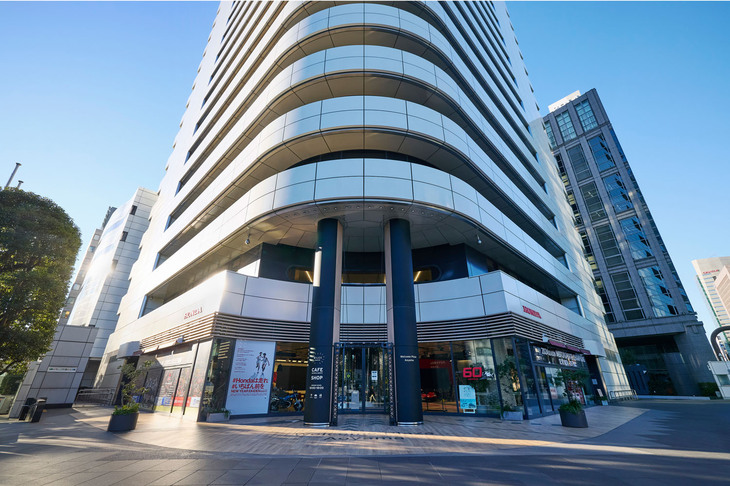 青山一丁目の交差点に向かってつくられた「Honda青山ビル」のメインエントランス。ビルの完成直前に視察した本田宗一郎氏が、エントランスにある2本の柱を見て「円い柱は大銀行のようであり権威的」と激怒したエピソードは有名である。柱はすぐにスリム化した小判型に変更された。