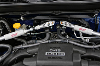 スチール製の「フレキシブルVバー」は、中間（写真左側、ゴムカバーをずらして露出させた部分）にピロボールが組み込まれている。これにより、軸方向の剛性は確保しながら、曲げやねじりといった力を逃がすことができるという。
    