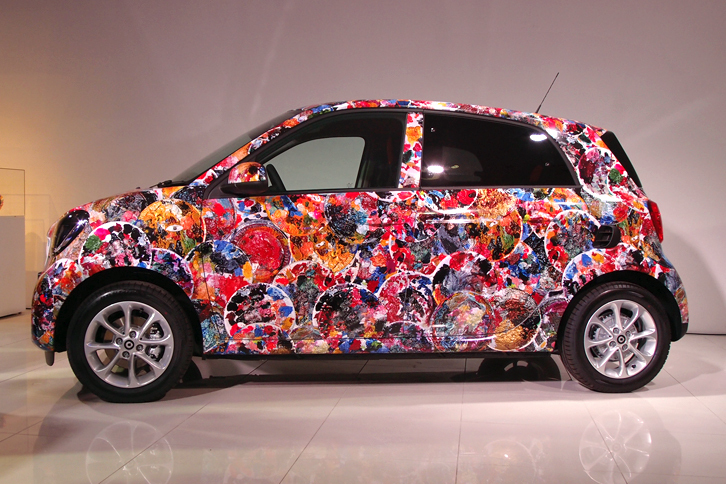 画家 横尾忠則氏の展覧会「横尾忠則 迷画感応術」に出展される、「スマート・フォーフォー」のアートカー。氏が絵画制作の際に使う“紙皿の絵画パレット”をもとにした絵柄で、ボディー全体が覆われている。