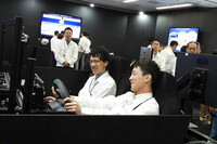 AIアシスタント機能「In-Cabinエージェント」のコーナーでは、AIによる車内・車外の状況認識が、実演を通して解説された。写真は、クルマのインテリアを模した模型に乗り込む、ホンダの実演スタッフ。