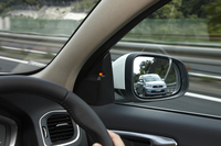 「ブラインドスポット・インフォメーション・システム」作動時の様子。Aピラー下端付近のランプを点灯することで、死角から迫る他車両の存在をドライバーに知らせる。
    