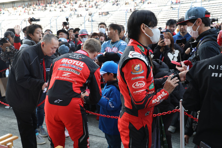 ちびっ子ファンに対応するロニー・クインタレッリ選手と千代勝正選手の「MOTUL AUTECH Z」コンビ。